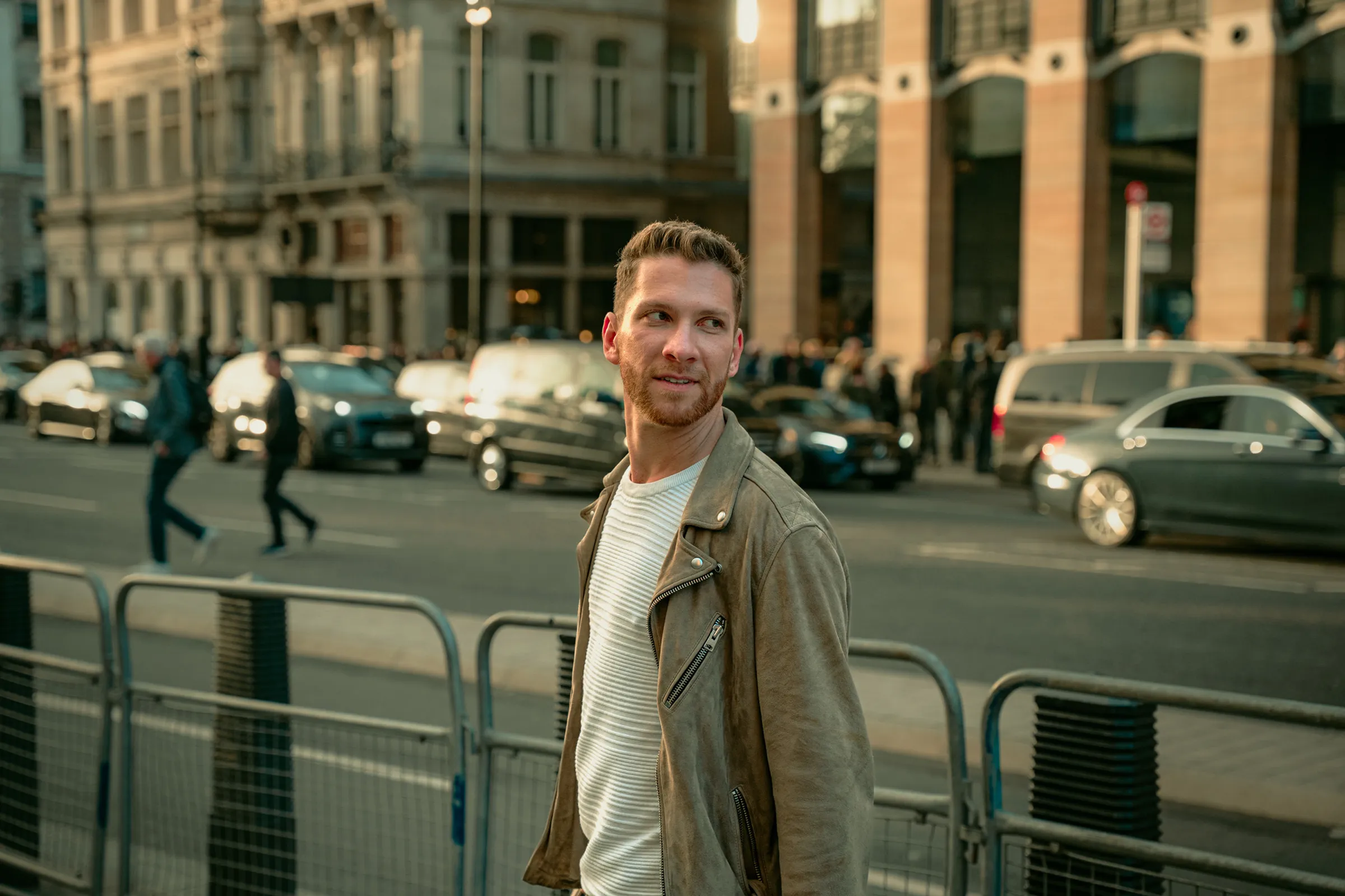 Street portrait of a man glancing back on a busy city road