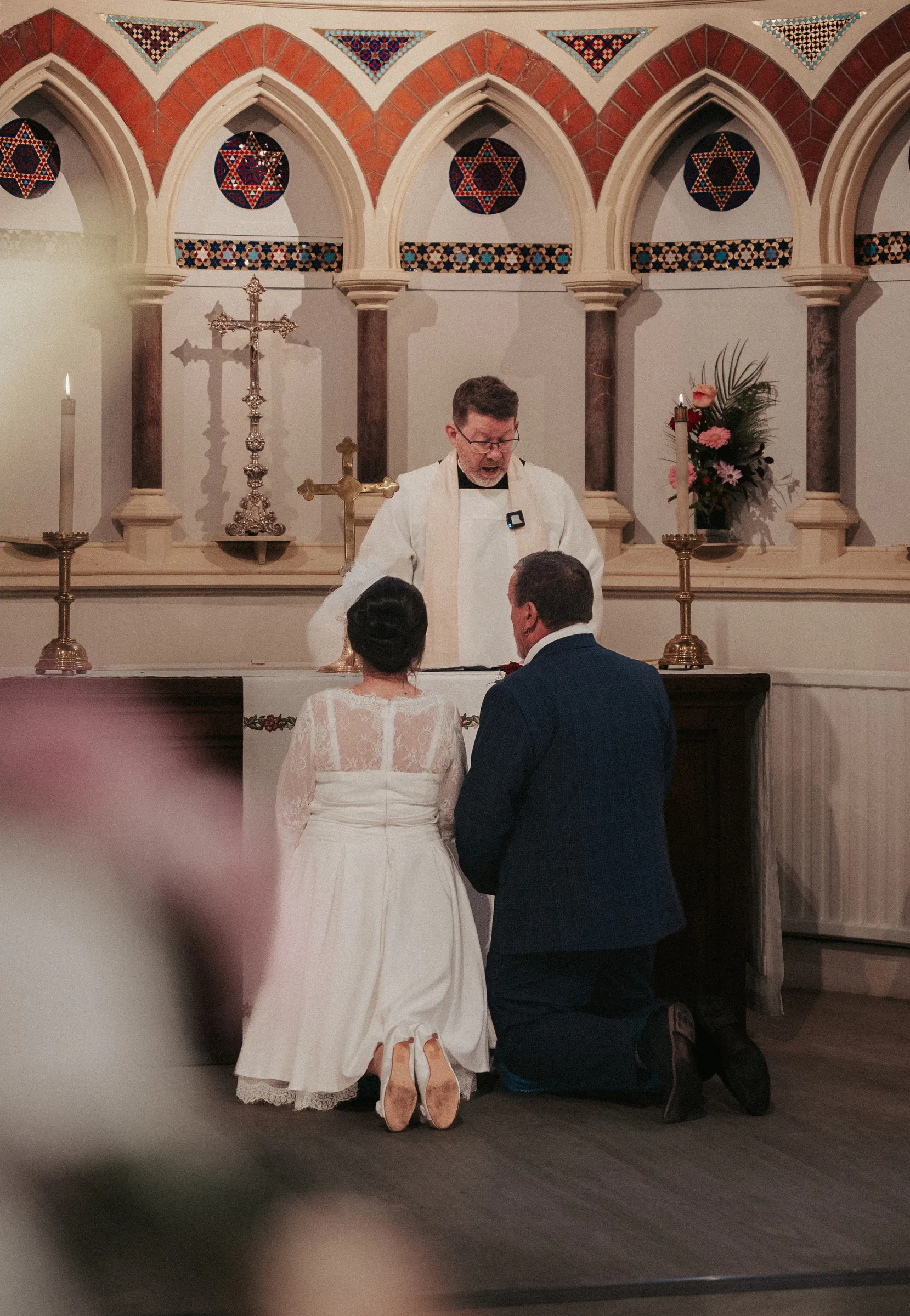 The couple kneeling together at the altar during the blessing