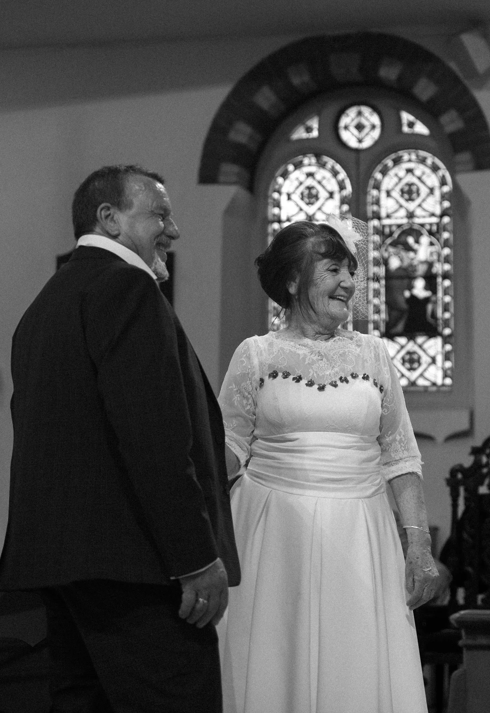 Black and white portrait of the couple laughing during the ceremony